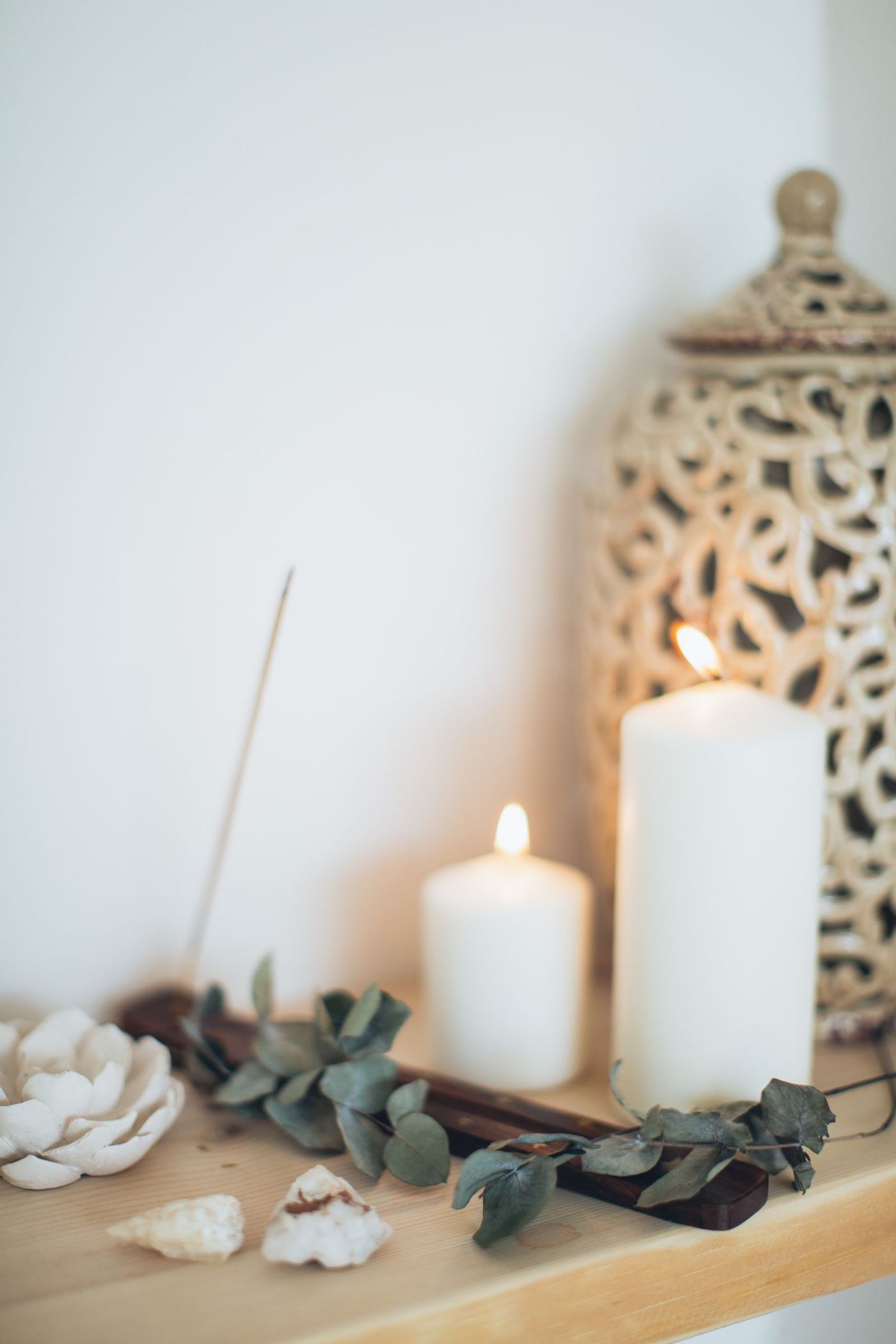 Candles and incense on a wooden shelf in soft light