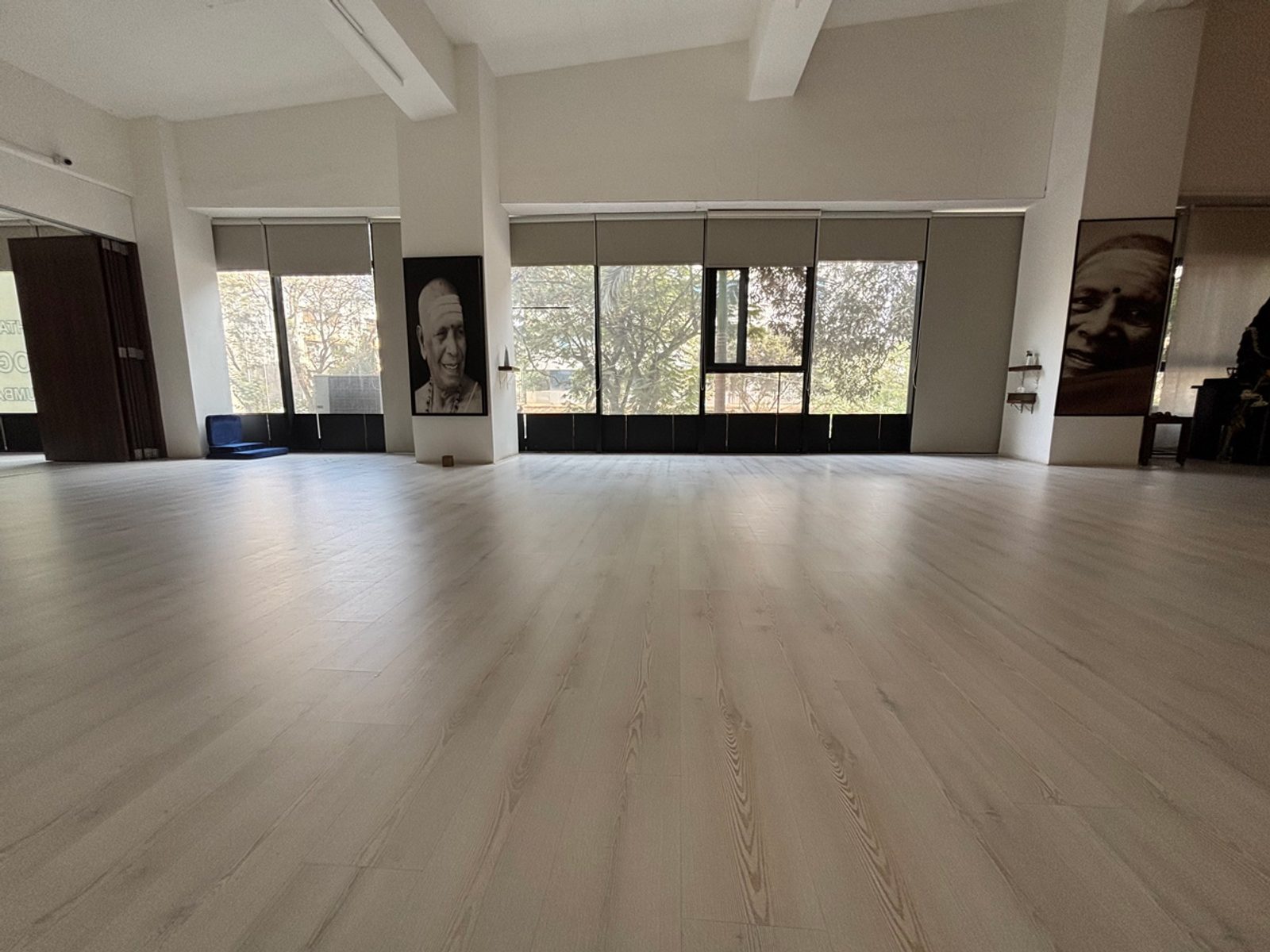 Wide wooden floor of the shala with framed portraits on the wall